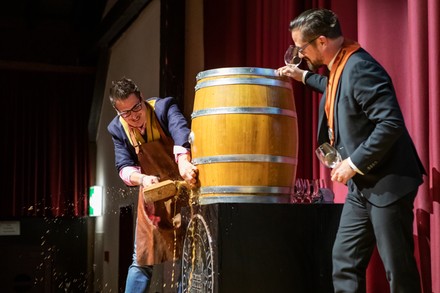 Giuliano Genoni hält einen Holzhammer und zapft ein Bierfass an