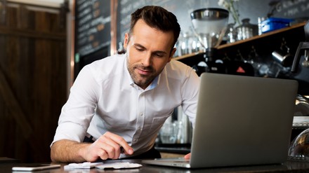 Gastronom bearbeitet etwas vor einem Computer
