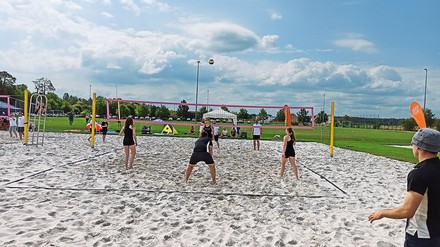 Menschen spielen Beachvolleyball.