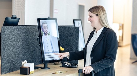Ein Gast interagiert beim Einchecken mit dem Avatar Fritz.