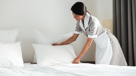 Zimmermädchen bereitet ein Hotelbett vor
