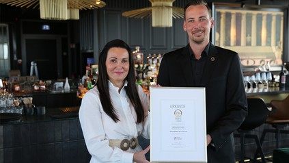 Diana Brinkmann, Geschäftsführerin, und Tim Althof, stv. Geschäftsführer, vom Braunschweiger Restaurant ÜBERLAND präsentieren die Urkunde „Arbeitgeber der Zukunft".