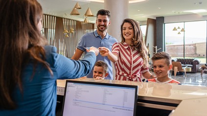 Familie beim Hotel-Check-in