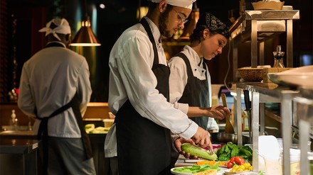 Koch schält Zucchini in der Küche