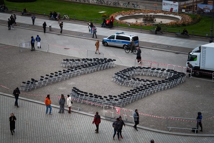Schwarze, leere Stühle formen eine 19