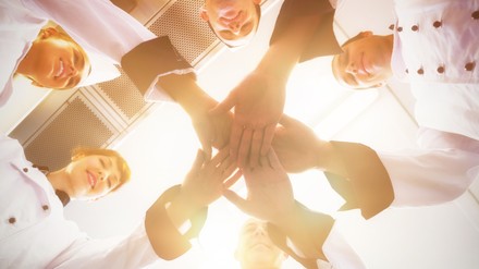 Team hält die Hände in die Mitte