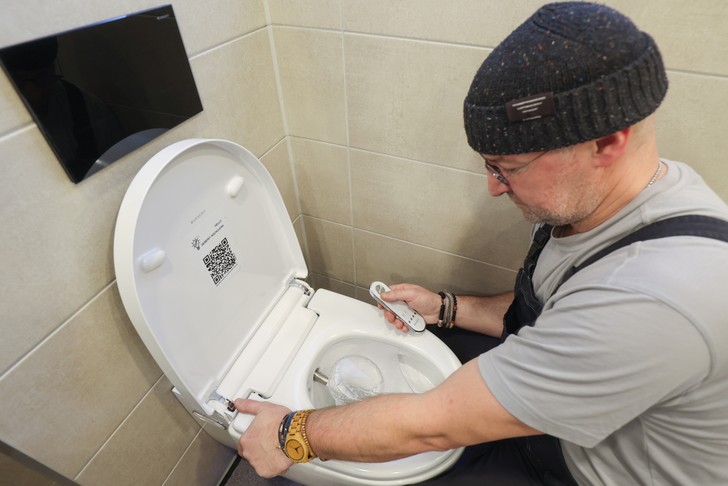 Nach erfolgter Installation testet der Monteur die Funktionen des Dusch-WCs, wie zum Beispiel den körperwarmen Wasserstrahl.  (Foto: © Geberit)