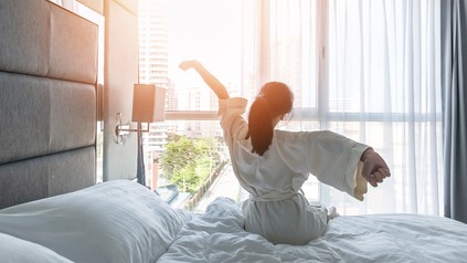 Frau wacht im Hotelzimmer auf