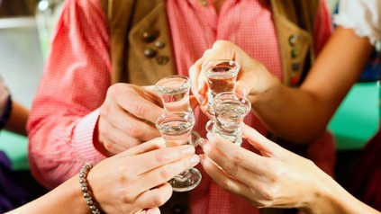 Vier Personen stoßen mit Schnaps an