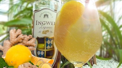 Ein Cocktail neben einer Likörflasche