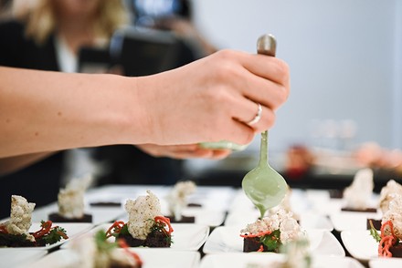 Ein veredeltes Fischtatar wird angerichtet.