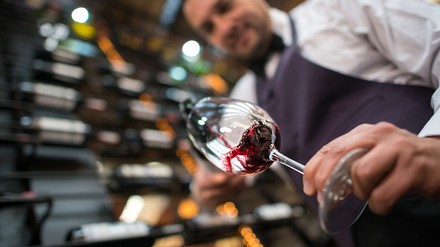 Kellner schenkt Wein in ein Glas ein