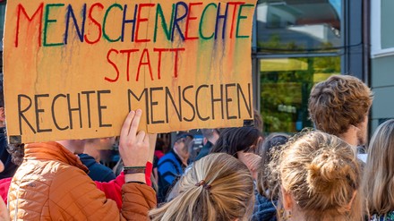 Junge Menschen protestieren mit einem Schild gegen Rechts