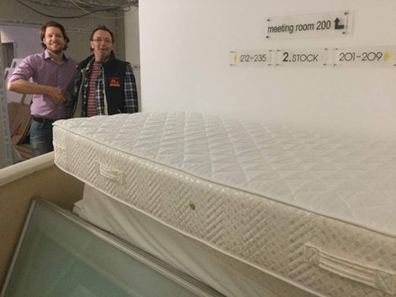 Zwei Männer hinter Matratze