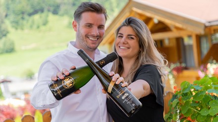 Nadja und Christian Unterlechner mit jeweils einer Weinflasche