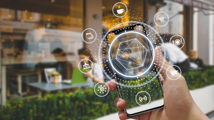 Eine Hand hält ein Handy mit KI Software