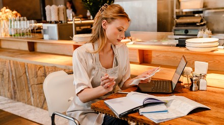 Frau schaut auf Abrechnung im Restaurant