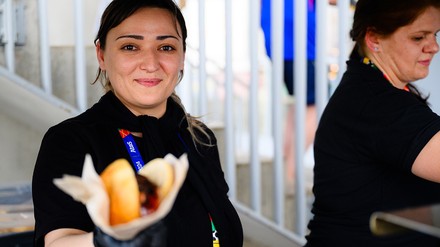 Aramark-Mitarbeiterin mit Bratwurst