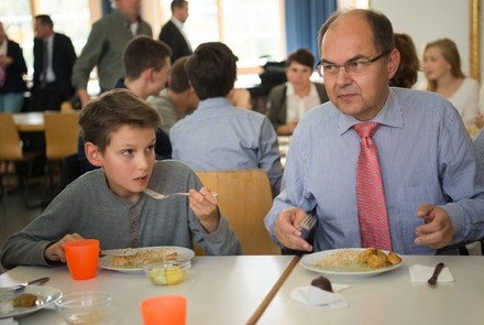Christian Schmidt isst mit einem Kind in einer Kita.