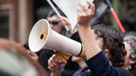 Ein Streikender mit einem Megafon