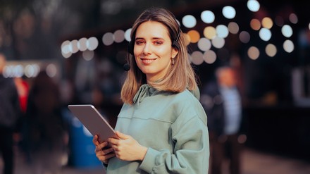 Frau mit Tablet und Headset auf einer Veranstaltung