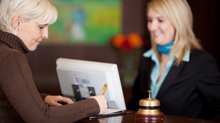 Frau unterschreibt an der Rezeption