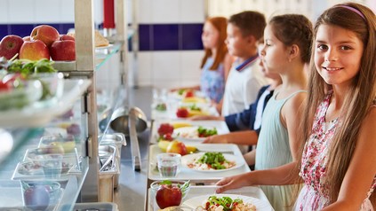 Kinder bei der Essensausgabe in der Schulkantine