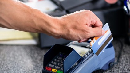 Mann zieht EC Karte durch EC Karten Lesegerät
