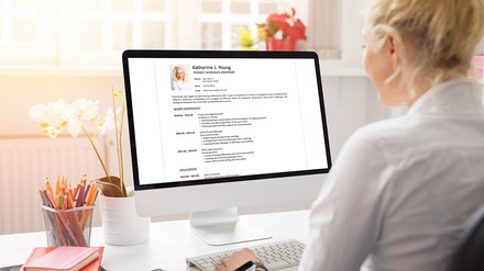 Junge Frau sitzt am PC und schreibt Ihren Lebenslauf