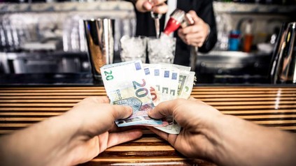 Mann hält Wirt mehrere Euro Scheine hin
