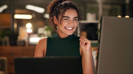 Junge Frau freut sich vor ihrem PC