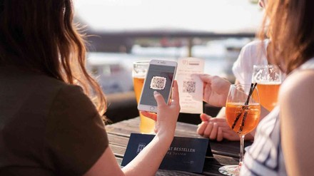 Frau mit Smartphone erhält ihren Bon dank QR-Code