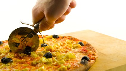 Pizzaschneider schneidet Pizza