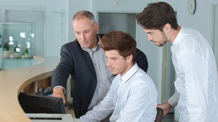 Zwei Azubis werden an der Rezeption angelernt