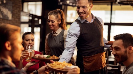 Kellner bringen Gerichte an den Tisch