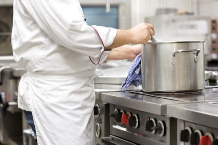 Ein Koch rührt in einem Topf