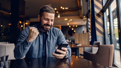 Mann im Restaurant nutzt sein Handy.