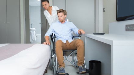 Rollstuhlfahrer im Hotelzimmer