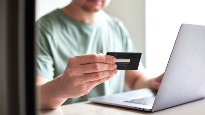 Mann bezahlt im Internet mit Kreditkarte