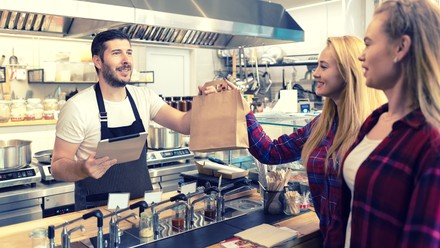 Essen zum Mitnehmen wird an der Theke überreicht