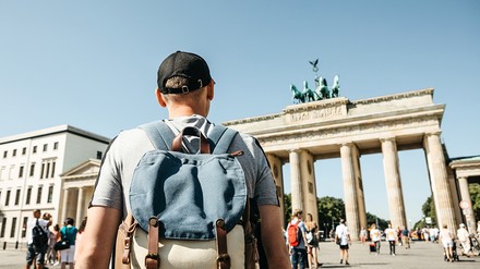 Tourist mit Rucksack vor dem Brandenburger Tor in Berlin