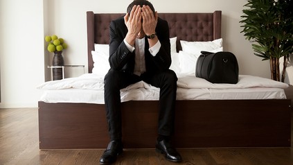 Ein gefrusteter Mann in einem Hotelzimmer