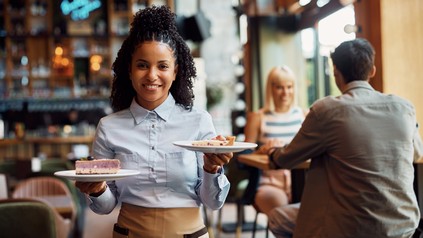 Servicekraft mit Kuchen in den Händen