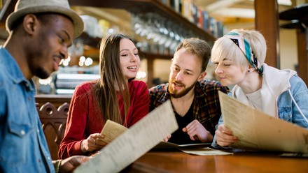 Gruppe junger Menschen schauen auf Speisekarte