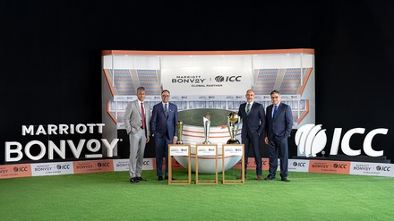 Repräsentanten von Marriott Bonvoy und dem International Cricket Council stehen vor einer Stadionkulisse mit Cricket-Pokalen bei der Vorstellung ihrer globalen Partnerschaft.