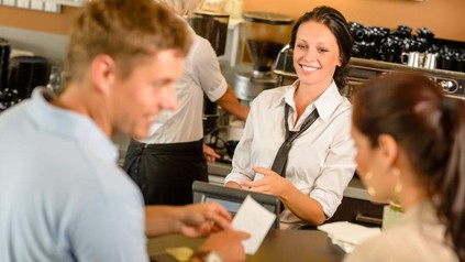 Kellnerin bedient Kunden an Kasse