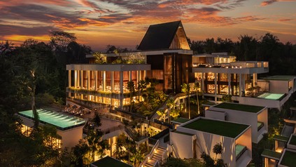 Modernes Luxusresort von Minor Hotels in tropischer Umgebung bei Sonnenuntergang mit Poolanlagen und beleuchteten Gebäuden.