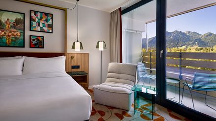 Hotelzimmer im Flesslers Lenggries mit Balkon und Bergblick, Teil des Tribute Portfolio von Marriott International.