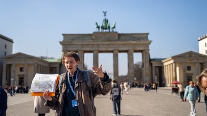 Stadtführer Leon Gordobil vom Tourenveranstalter Original Berlin Walks steht vor dem Brandenburger Tor.