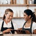Mitarbeiter in einem Café besprechen gemeinsam Inhalte auf einem Tablet